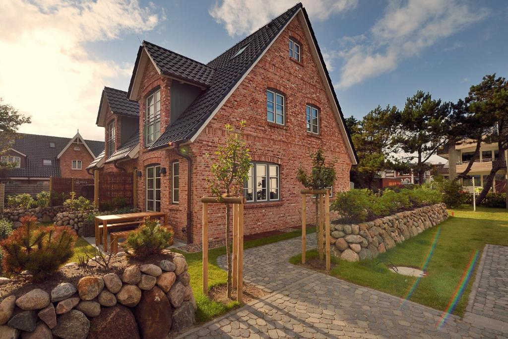 une maison en briques avec un jardin en face de celle-ci dans l'établissement Ocean House - mittendrin und trotzdem ruhig, à Westerland