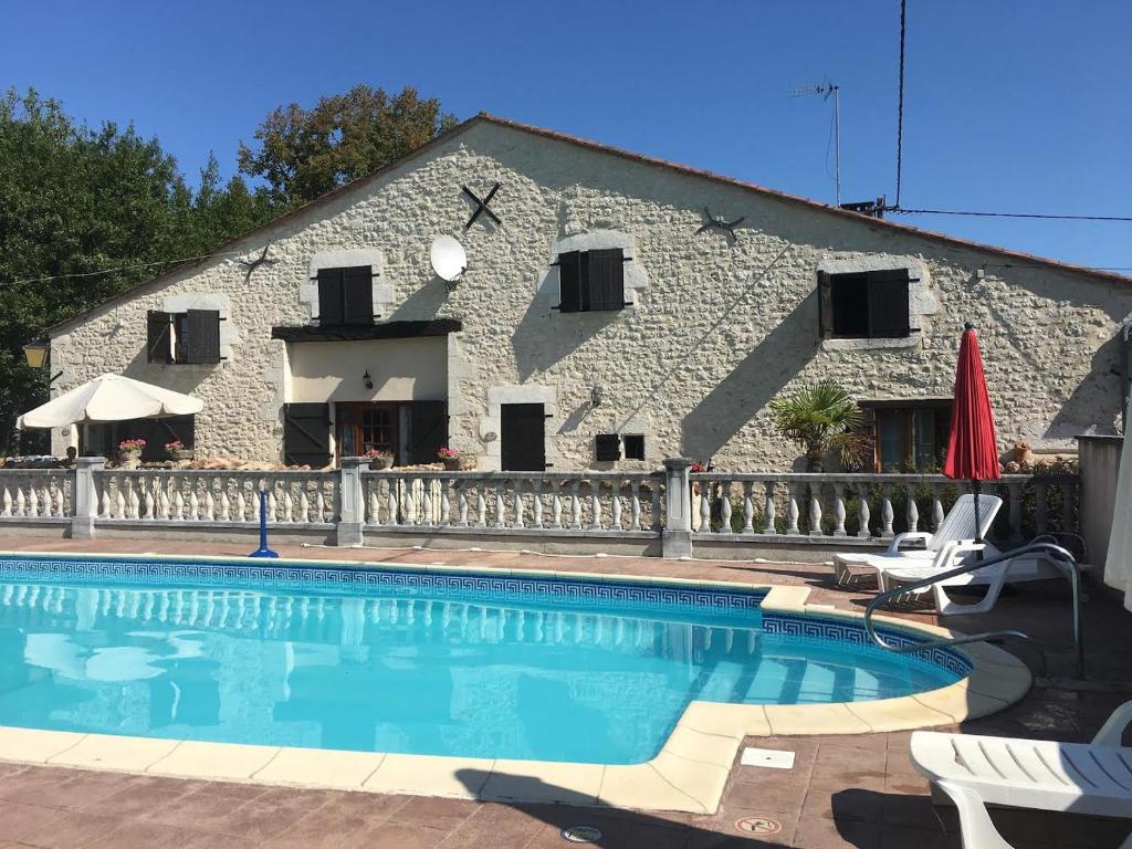 a swimming pool in front of a building at LES GRANGES in Les Lèves-et-Thoumeyragues