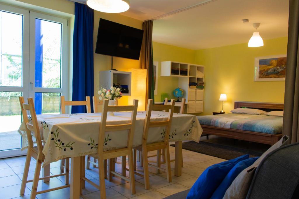 - une salle à manger avec une table, des chaises et un lit dans l'établissement Wonderful Apartment With Great Location, à Kaiserslautern