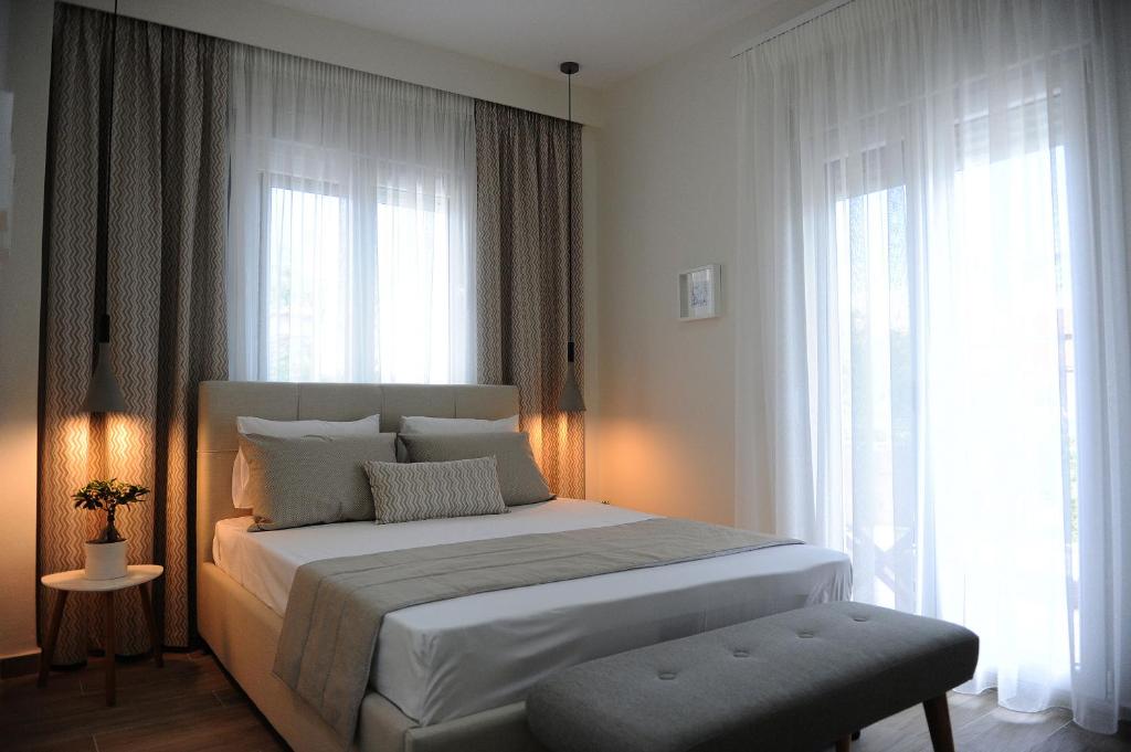 sypialnia z dużym białym łóżkiem i oknami w obiekcie Stamatia Apartments w mieście Asprovalta