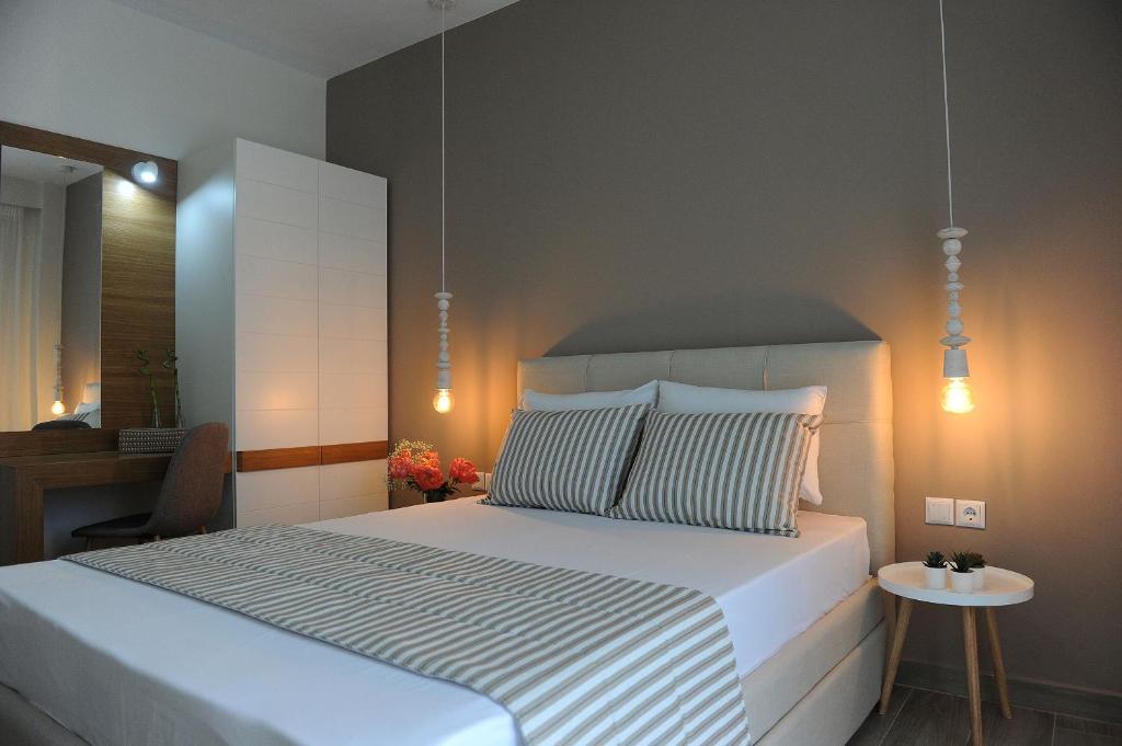 ein Schlafzimmer mit einem großen weißen Bett und einem Tisch in der Unterkunft Stamatia Apartments in Asprovalta