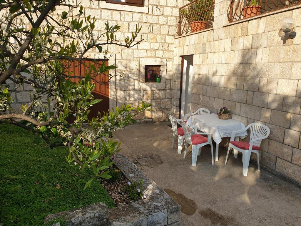 una mesa y sillas blancas con una mesa y un sillón blancos en Studio Airport Dubrovnik, en Čilipi