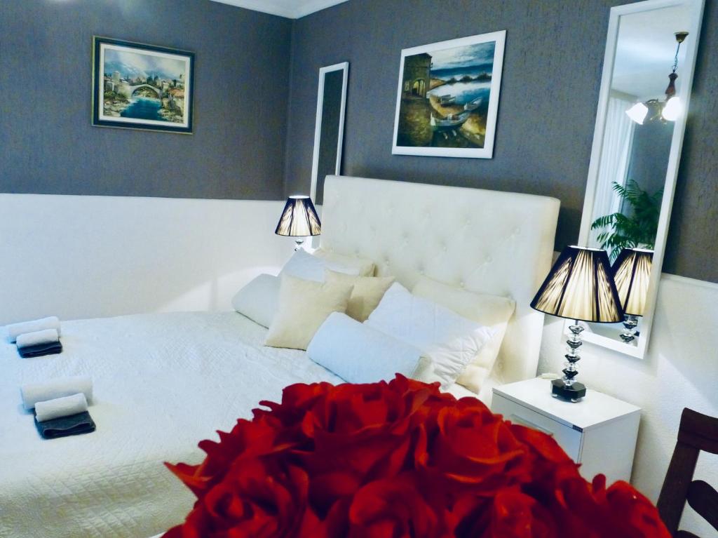 a bedroom with a white bed with a red flower on it at Studio Nina in Umag