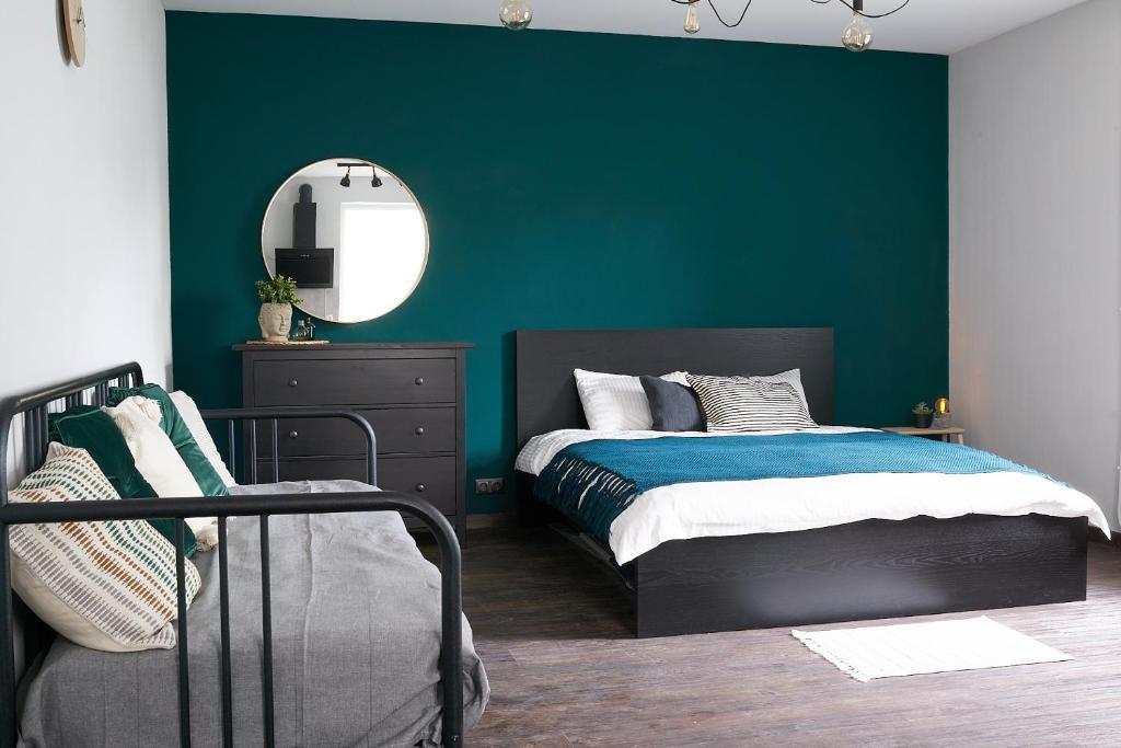 a bedroom with green walls and a bed and a mirror at Greenhouse Apartments in Jūrmala