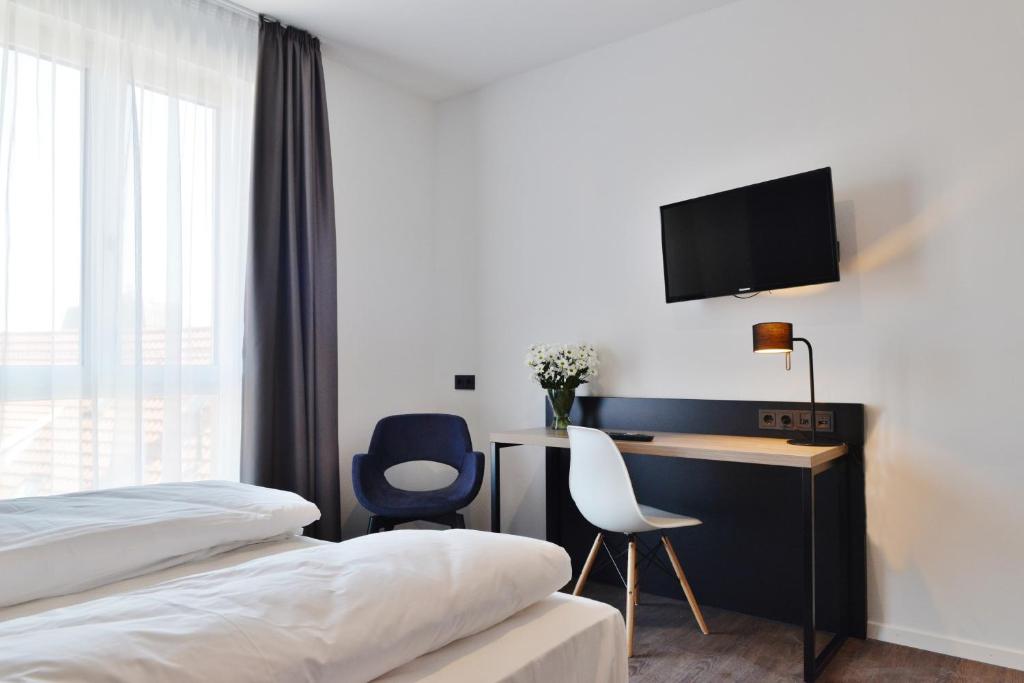 a hotel room with a bed and a television at Hayta Hotel Stuttgart Airport Messe in Filderstadt
