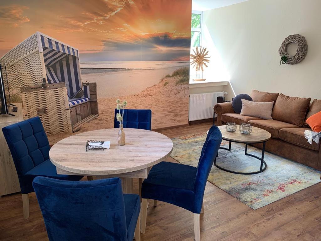 sala de estar con mesa y sillas azules en FEWO Spiekeroog, en Bad Zwischenahn