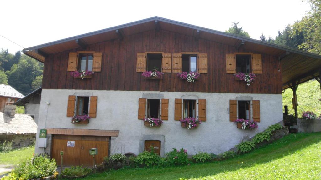 a house with flowers on the windows of it at Gites le Criou et le Moulin in Morillon