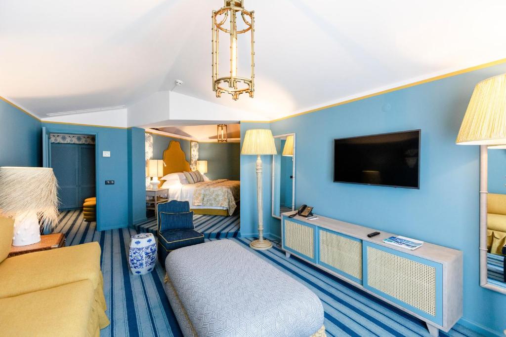 a hotel room with blue walls and a bed and a tv at The Albatroz Hotel in Cascais