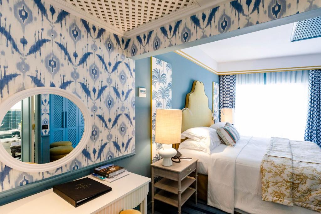 a bedroom with a bed and a mirror at The Albatroz Hotel in Cascais