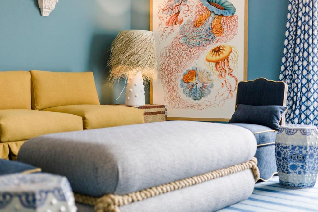 a living room with a couch and a ottoman at The Albatroz Hotel in Cascais