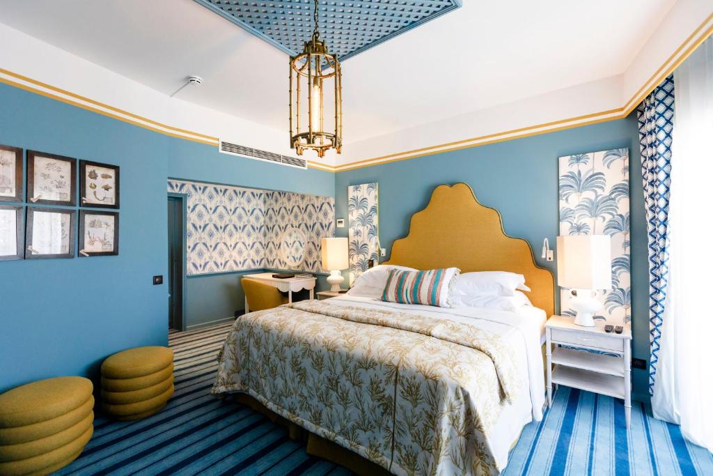 a bedroom with a large bed and blue walls at The Albatroz Hotel in Cascais