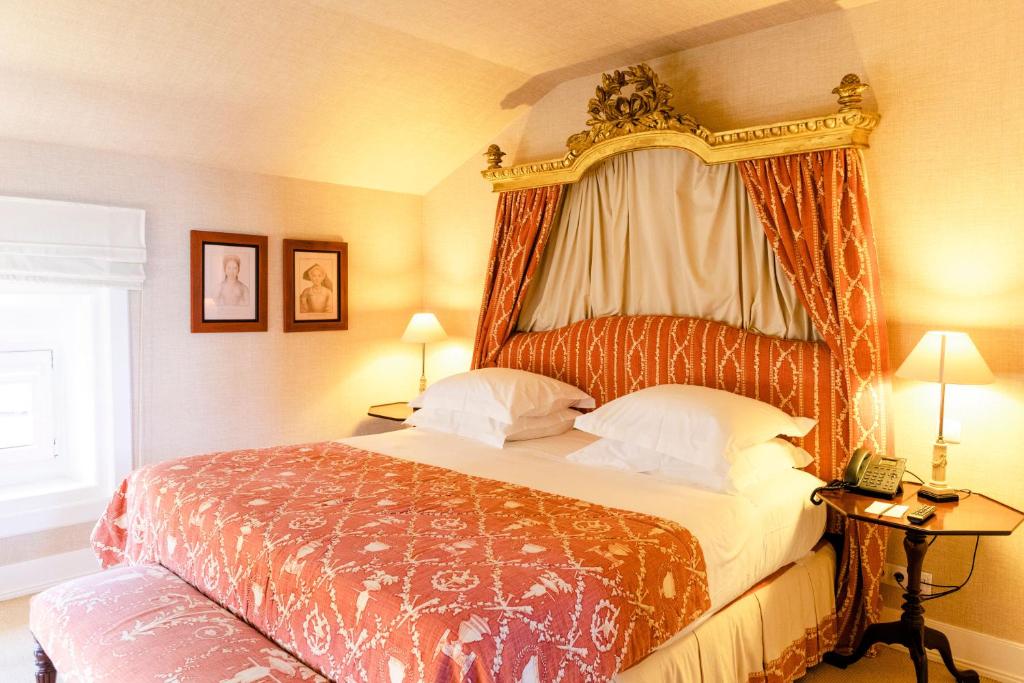 a bedroom with a large bed with a canopy at The Albatroz Hotel in Cascais