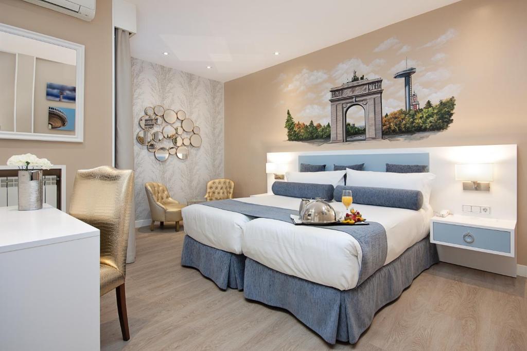 a bedroom with a king sized bed and a kitchen at Hotel Mayorazgo in Madrid