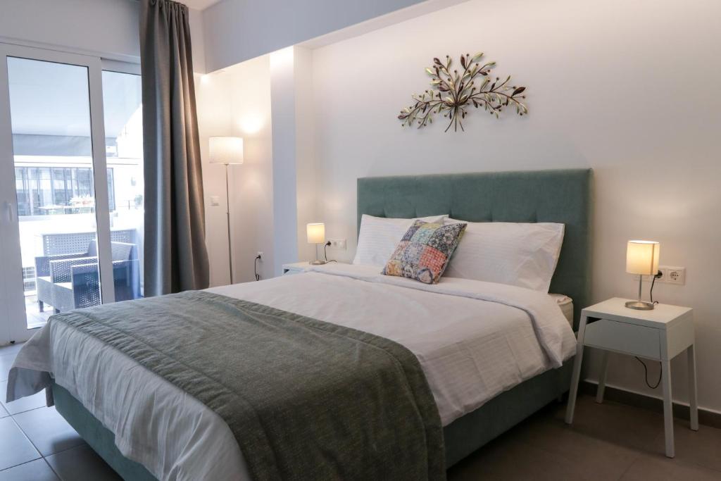 a bedroom with a bed with two lamps and a window at V36 Suites in Athens