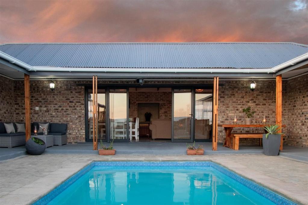 a house with a swimming pool and a patio at Parkside Guesthouse in Ladismith