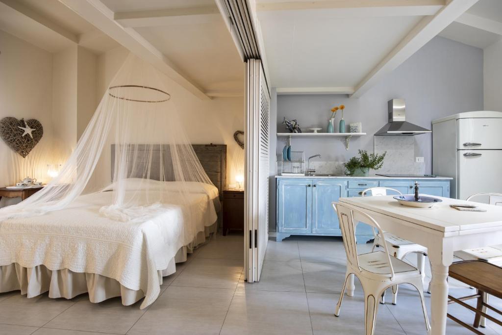 1 dormitorio con 1 cama y 1 mesa con sillas en Residenza Belmare, en Marina di Carrara