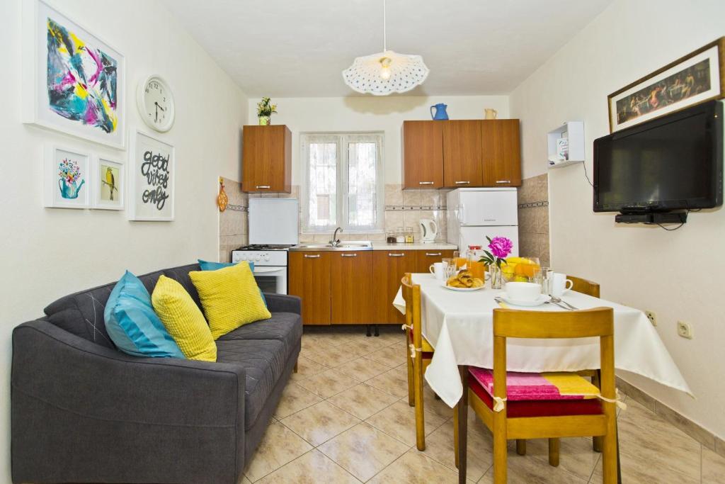 a living room with a table and a couch and a kitchen at Lina Vranković Apartments in Hvar