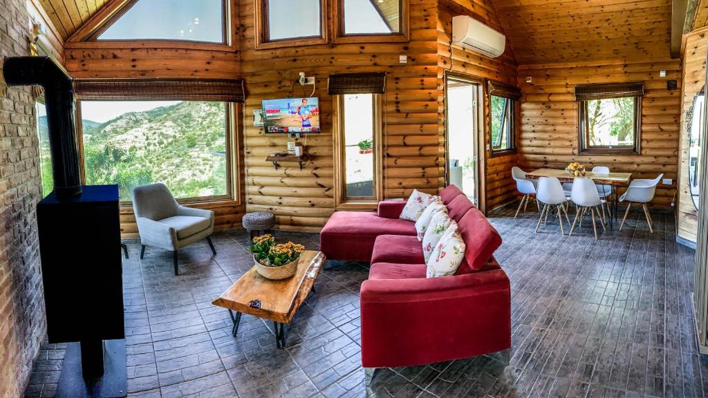 a living room with a red couch and a table at Vasiliou House Krimenos in Khandria