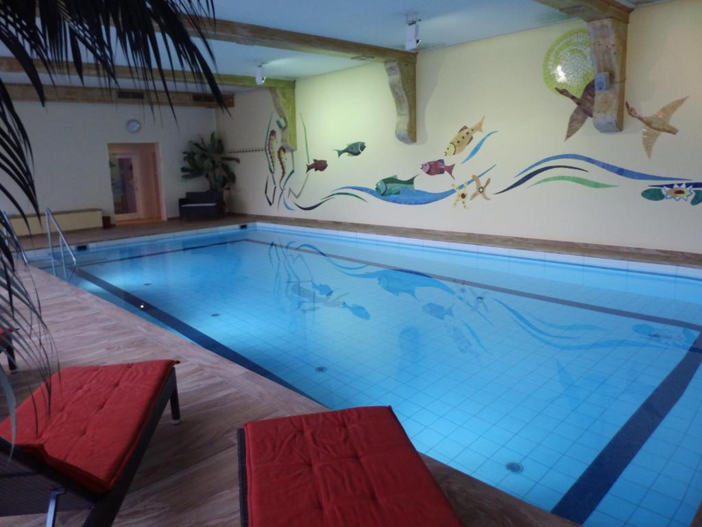 a swimming pool with a mural of fish on the wall at Parkhotel Weber-Müller in Bad Lauterberg
