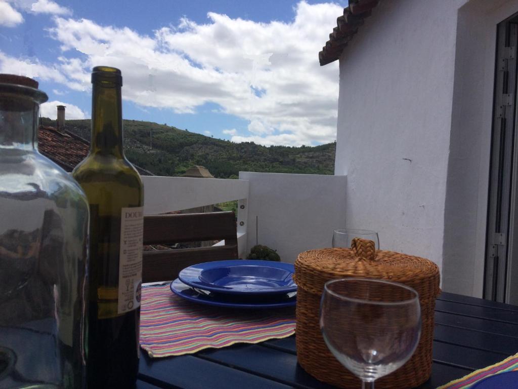 una botella de vino sentada en una mesa con una copa en Casa da Vila, en Castelo de Vide