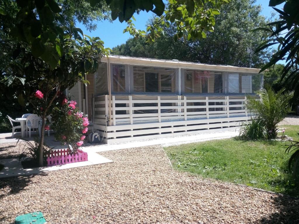ein Cottage im Garten mit einem weißen Zaun in der Unterkunft Le Panorama, 3 Ch, 43m2, climatisé, super équipé, draps, linge de maison inclus, terrasse fermable de 18m2 in Lattes
