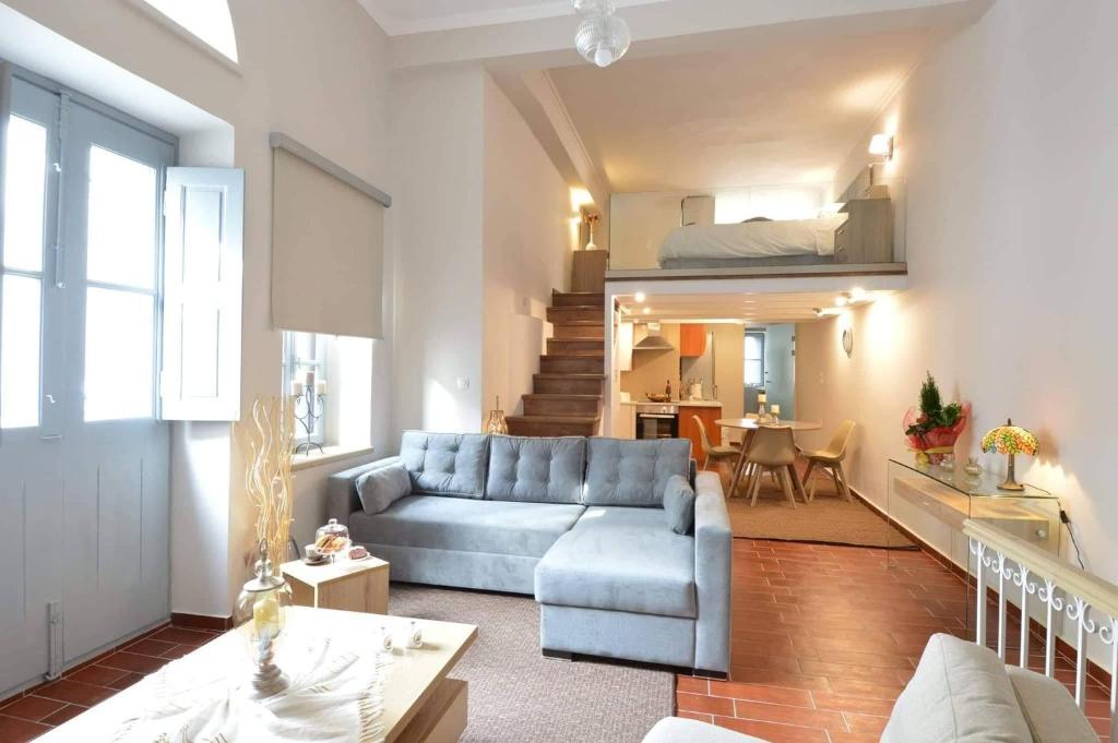 Kalymnos Suite home في كاليمنوس: غرفة معيشة مع أريكة زرقاء وسرير