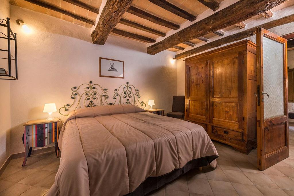 ein Schlafzimmer mit einem großen Bett in einem Zimmer in der Unterkunft Ca' Montalcino in San Giovanni dʼAsso