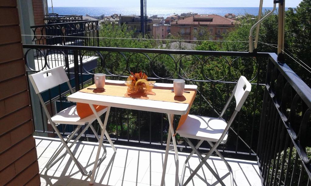 einen Tisch und zwei Stühle auf einem Balkon mit Aussicht in der Unterkunft Appartamento Lauretta in Ceriale