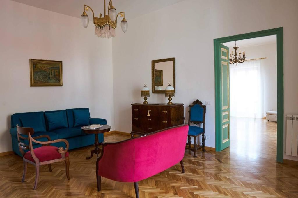 a living room with a blue couch and a table and chairs at Dimora Liberty autentica sicilianità in Pietraperzia