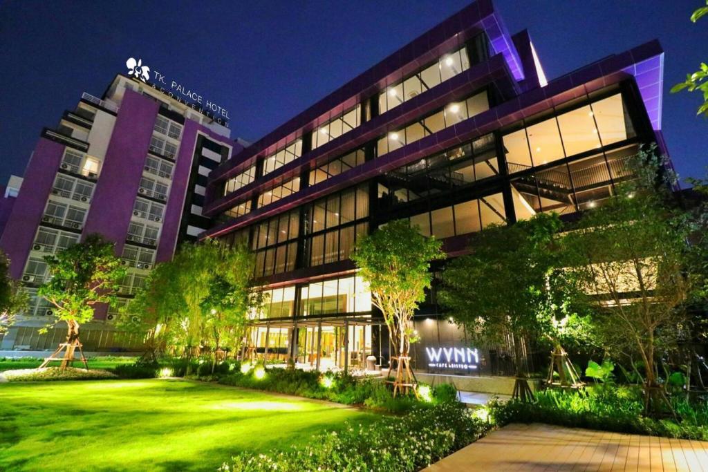 a building with a green lawn in front of it at TK Palace Hotel & Convention in Bangkok