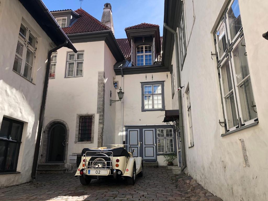 una vecchia auto parcheggiata di fronte a un edificio di Old Bishop's House a Tallinn