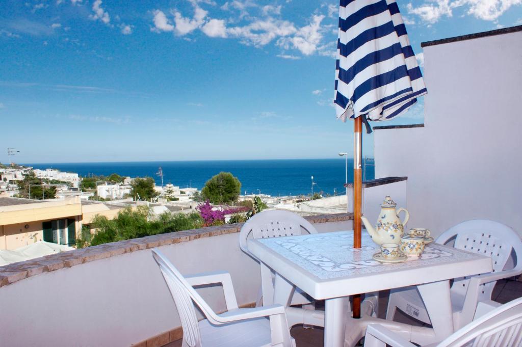 a table and chairs on a balcony with a view of the ocean at La Torre in Santa Cesarea Terme