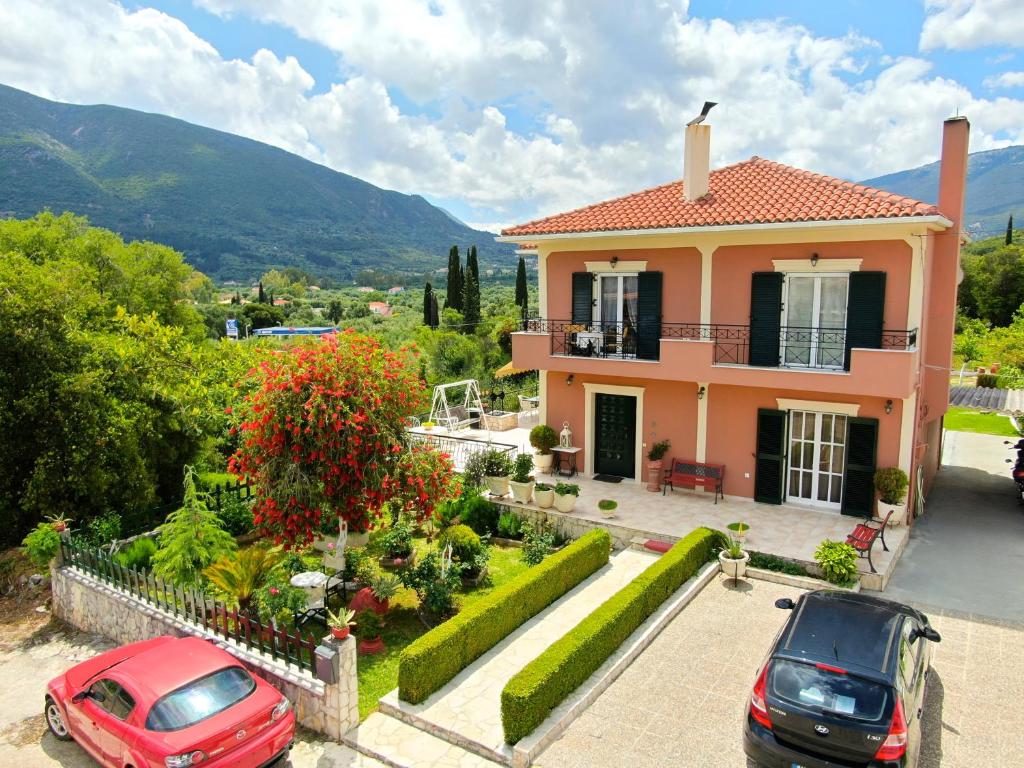 una casa con dos coches estacionados frente a ella en Ntina's house, en Karavomylos