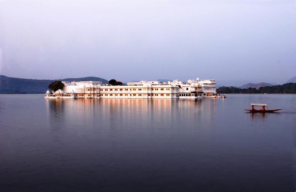 un grande edificio in mezzo a un corpo d'acqua di Taj Lake Palace Udaipur a Udaipur