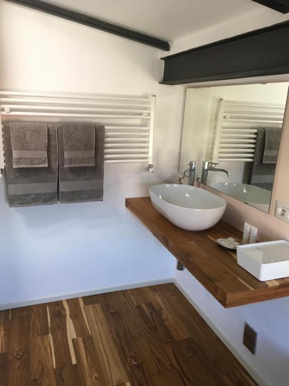 een badkamer met een witte wastafel en een spiegel bij La casa degli ulivi in Lierna