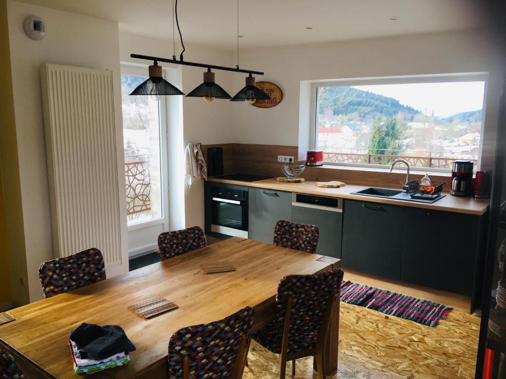 a kitchen with a wooden table and a table and chairs at Les Terrasses du Donon in Raon-lès-Leau