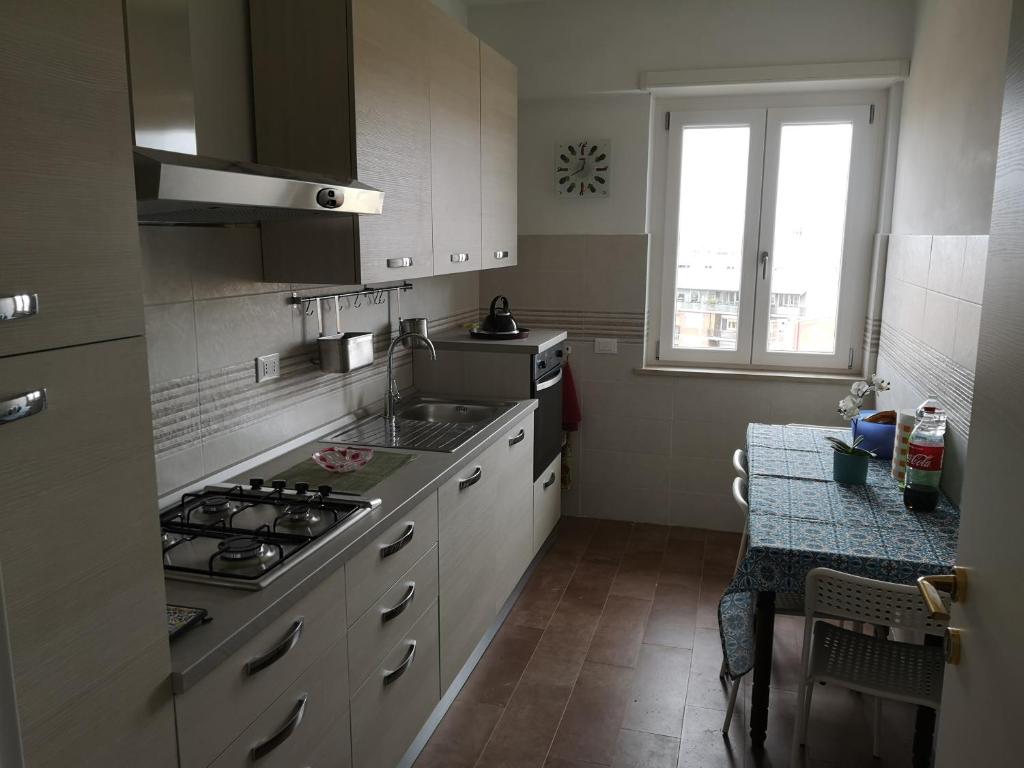 a kitchen with a stove and a sink and a table at My House in Rome in Rome