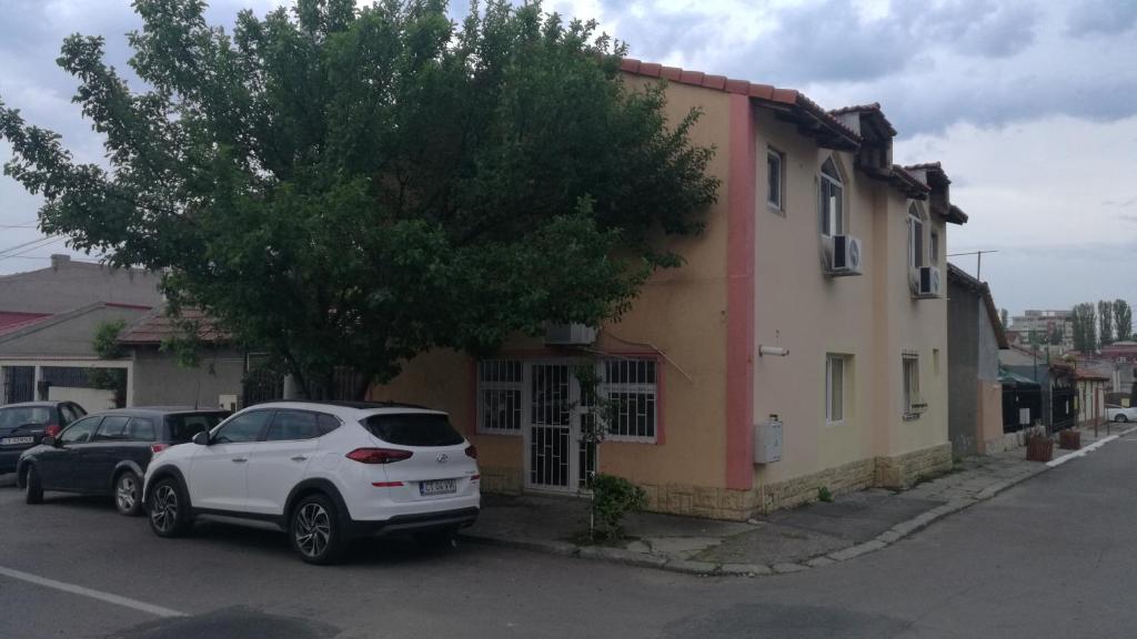 una macchina bianca parcheggiata di fronte a una casa di Cazare la mare vila Constanta a Constanţa