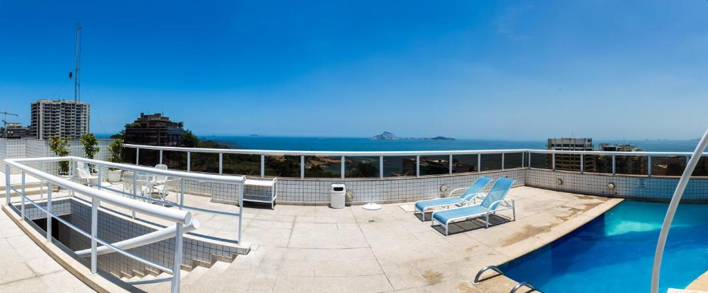 a balcony with a blue chair on a cruise ship at Atlantis Copacabana Hotel in Rio de Janeiro