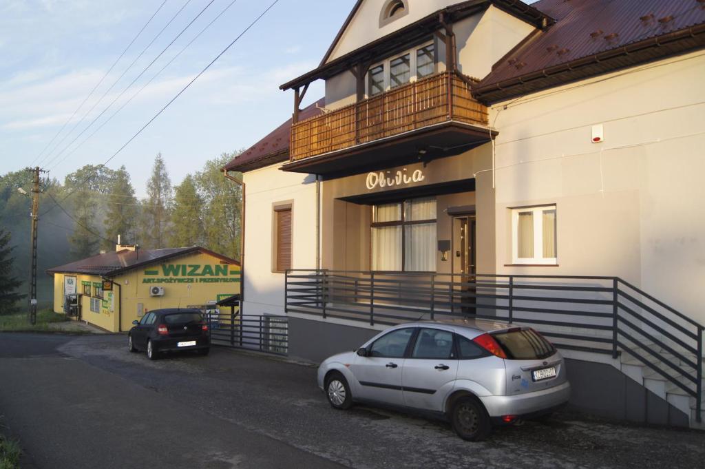 una macchina bianca parcheggiata di fronte a un edificio di OLIVIA a Osiek