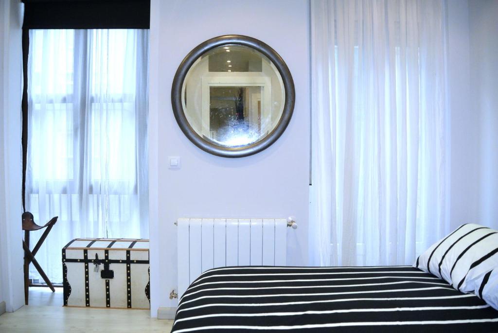 a bedroom with a black and white bed and a mirror at APARTAMENTO CENTRICO in Santander
