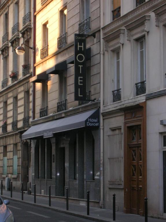 a building with a sign for a hotel on a street at Hotel Darcet in Paris