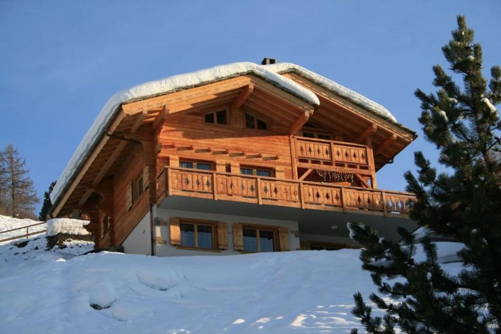 a log cabin with a balcony in the snow at Chalet Marie-Rose in Veysonnaz