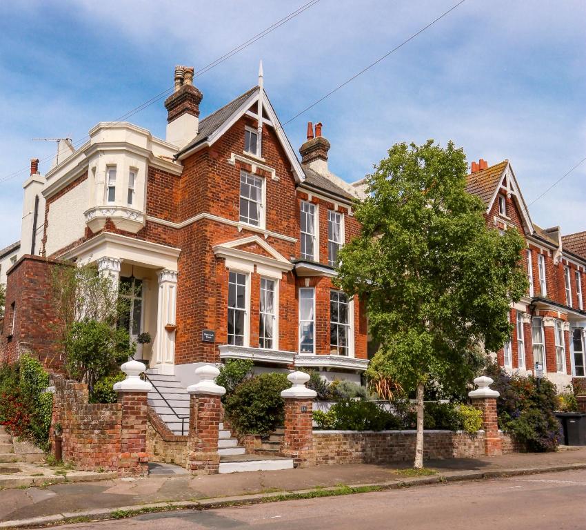 uma casa de tijolos vermelhos com uma árvore em frente em Black Rock House em Hastings