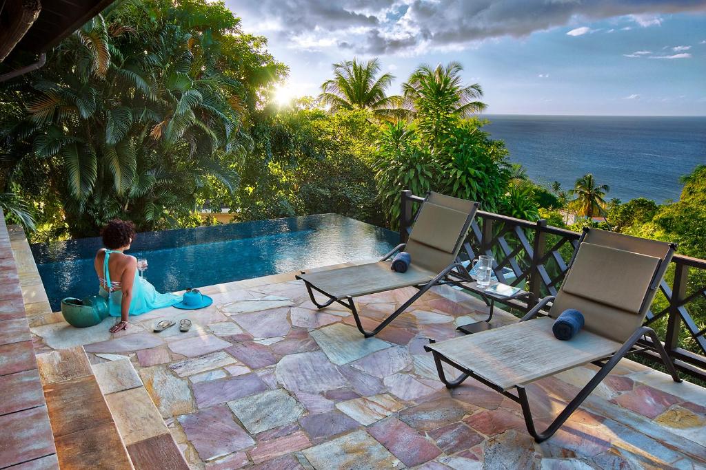 a young boy sitting next to a swimming pool at Villas at Stonehaven in Black Rock