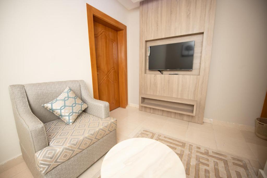 a living room with a chair and a flat screen tv at فندق قصر صيدا sayda palace hotel in Aḩad al Masāriḩah