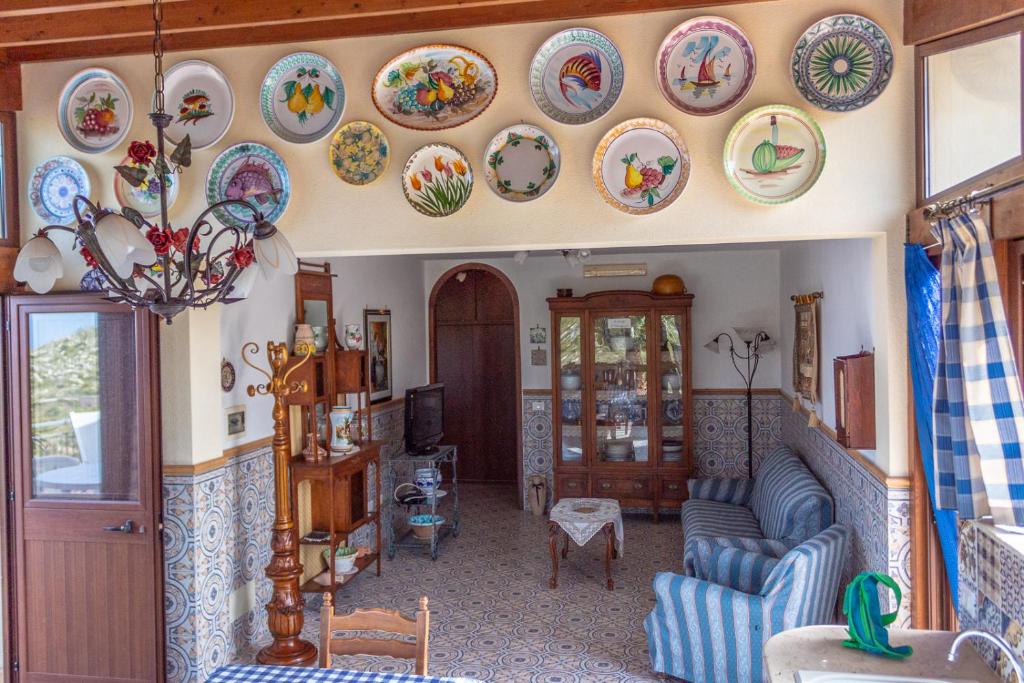 a living room with plates on the wall at Villa Azzurra con vista sul mare in San Vito lo Capo