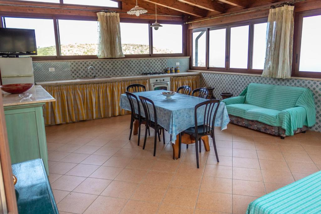 a kitchen and dining room with a table and chairs at Villa Verde con vista sul mare in San Vito lo Capo