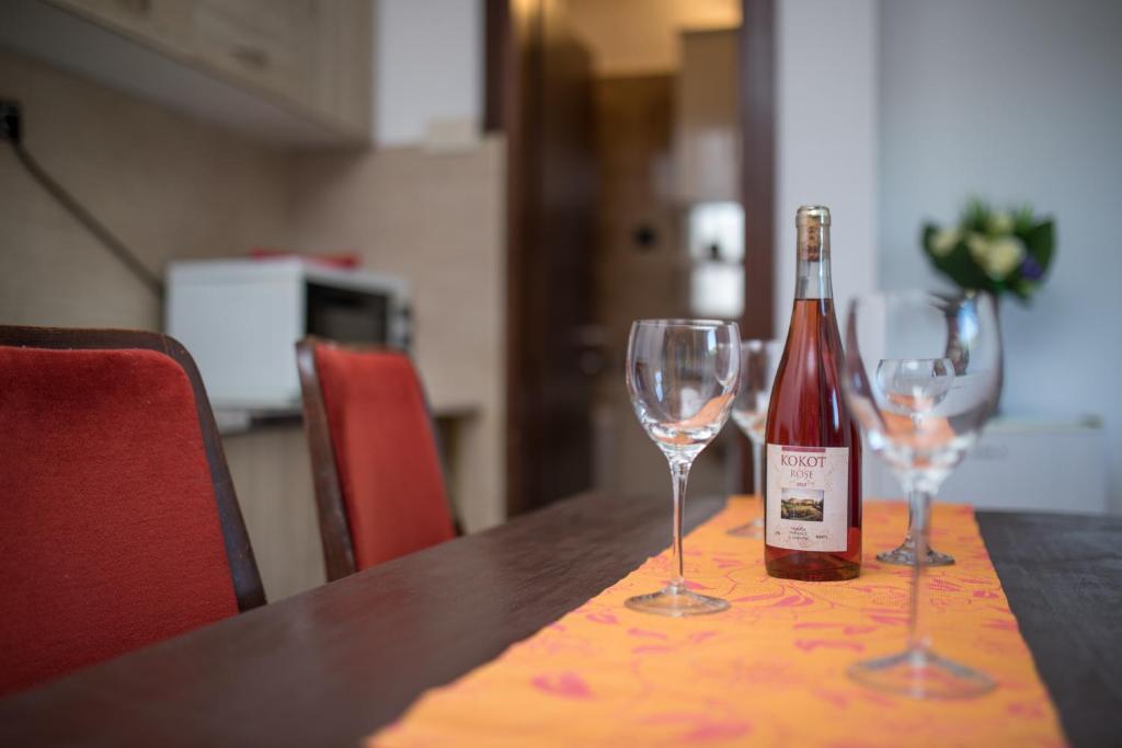 eine Flasche Wein auf einem Tisch mit zwei Weingläsern in der Unterkunft Guest House Zuber in Budva