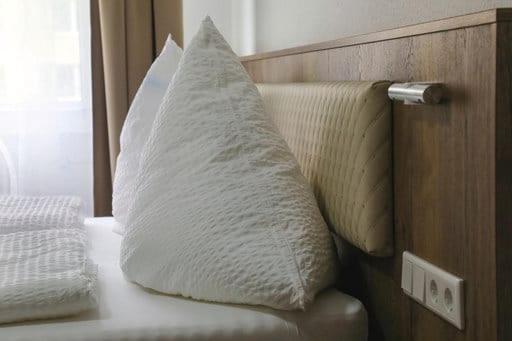 a pillow sitting on top of a bed at LOOK Hotel & Rooms in Crailsheim